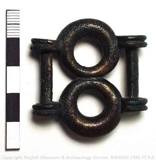 Photograph of an Iron Age copper alloy strap union found in a hoard at Ringstead. Photograph from MODES.