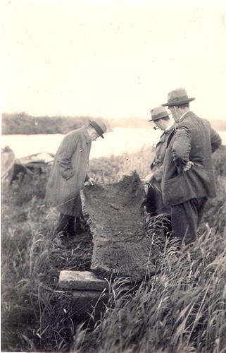 Photograph of the excavation of a wooden dug-out canoe that was dredged from the River Ant below Wayford Bridge in 1927. At first thought to be medieval, it was later dated to 720 AD.