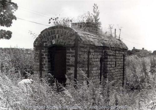 A 19th century wheelwright's oven showing the exterior of the barrel vaulted chamber and the central chimney stack.